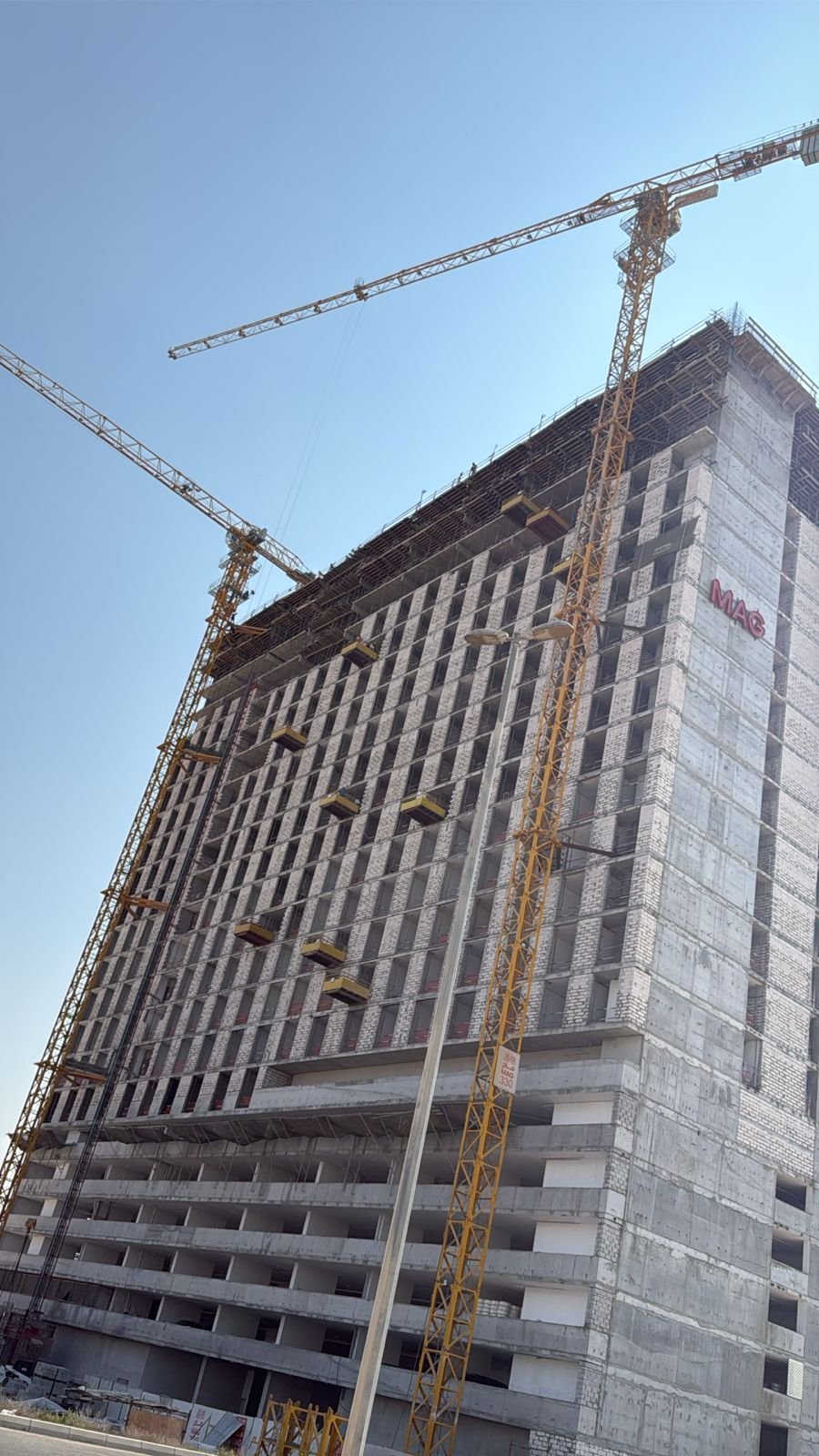 Tower crane overlooking an active high-rise construction project in Dubai.